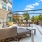 Spacious outdoor lounge area featuring multiple comfortable seating arrangements and modern grills