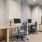A business center at Vista Wilde Lake featuring several workstations with computers, ergonomic chairs, and a wooden cabinet with a printer, offering a quiet space for residents to work