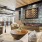 A modern clubroom at Vista Wilde Lake featuring cozy seating with decorative pillows, a large wooden coffee table, a fireplace with wall art, and industrial-style lighting
