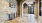 An office foyer at Vista Wilde Lake featuring exposed brick walls, arched doorways, a decorative console table, and large double doors leading to the outside