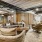  A spacious clubroom with lounge seating at Vista Wilde Lake, featuring comfortable chairs and sofas with decorative pillows, wooden accents, arched doorways, and industrial-style lighting